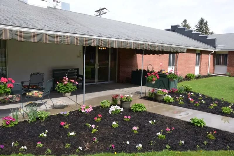 Exterior view of a facility with vibrant flowers and patio area