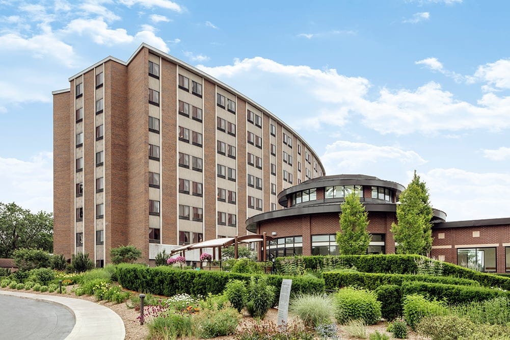 Exterior view of a nursing home building with garden area