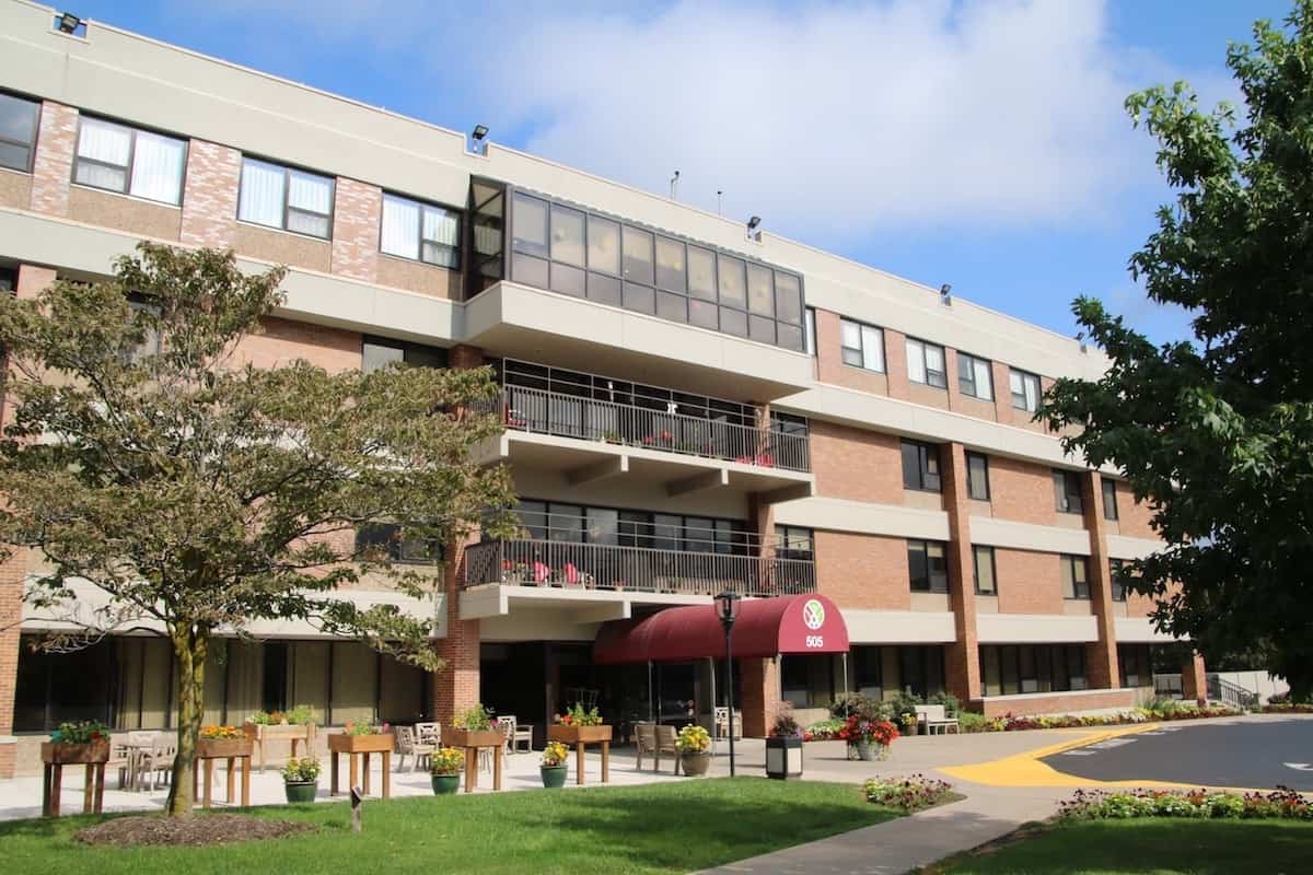 Exterior view of a senior living facility with gardens and walkways