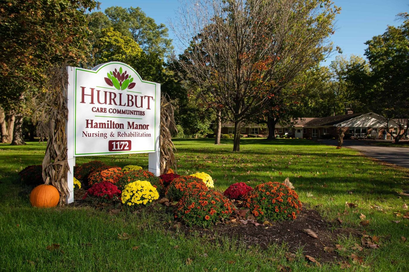 Signage for Hamilton Manor Nursing Home surrounded by flowers