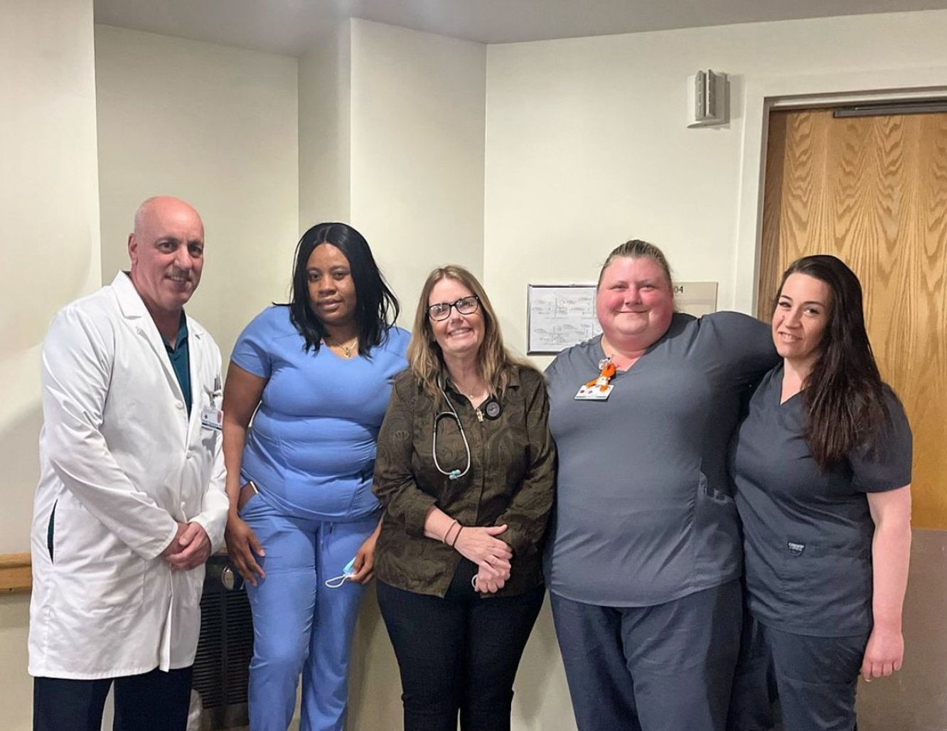 Staff members posing in a facility hallway