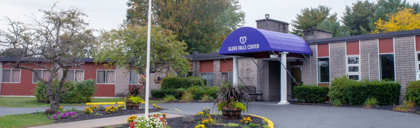 Front entrance of Glens Falls Center with colorful landscaping