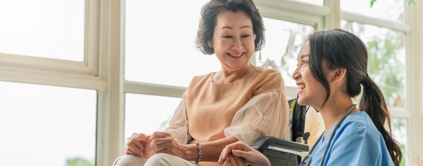 Caregiver and resident interacting warmly indoors