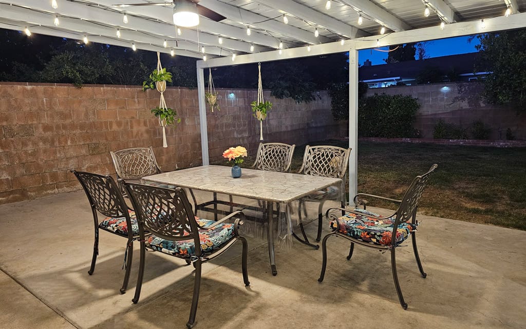 Outdoor dining area with a table and chairs under lights