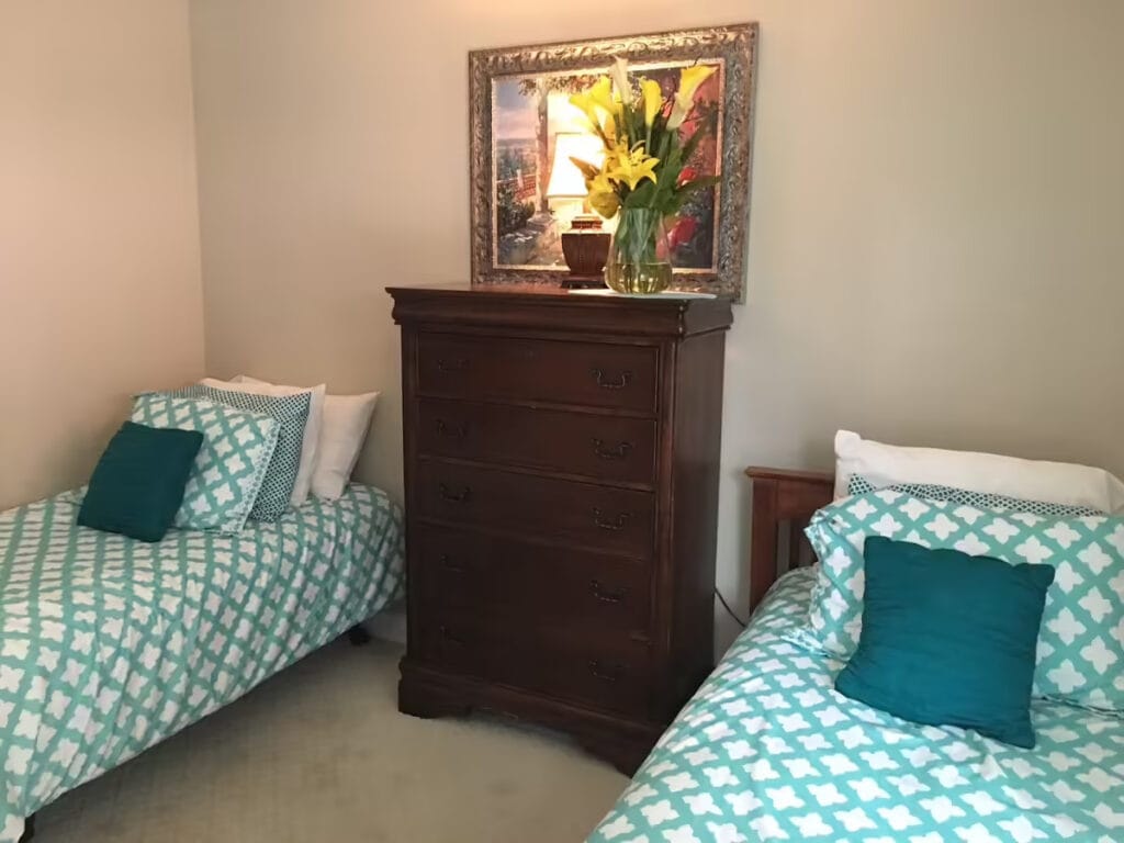 Cozy resident room with two beds and a dresser