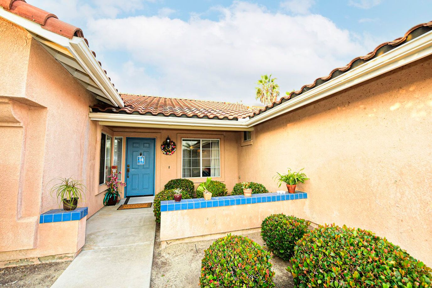 Front entrance of a senior living facility with decorative plants