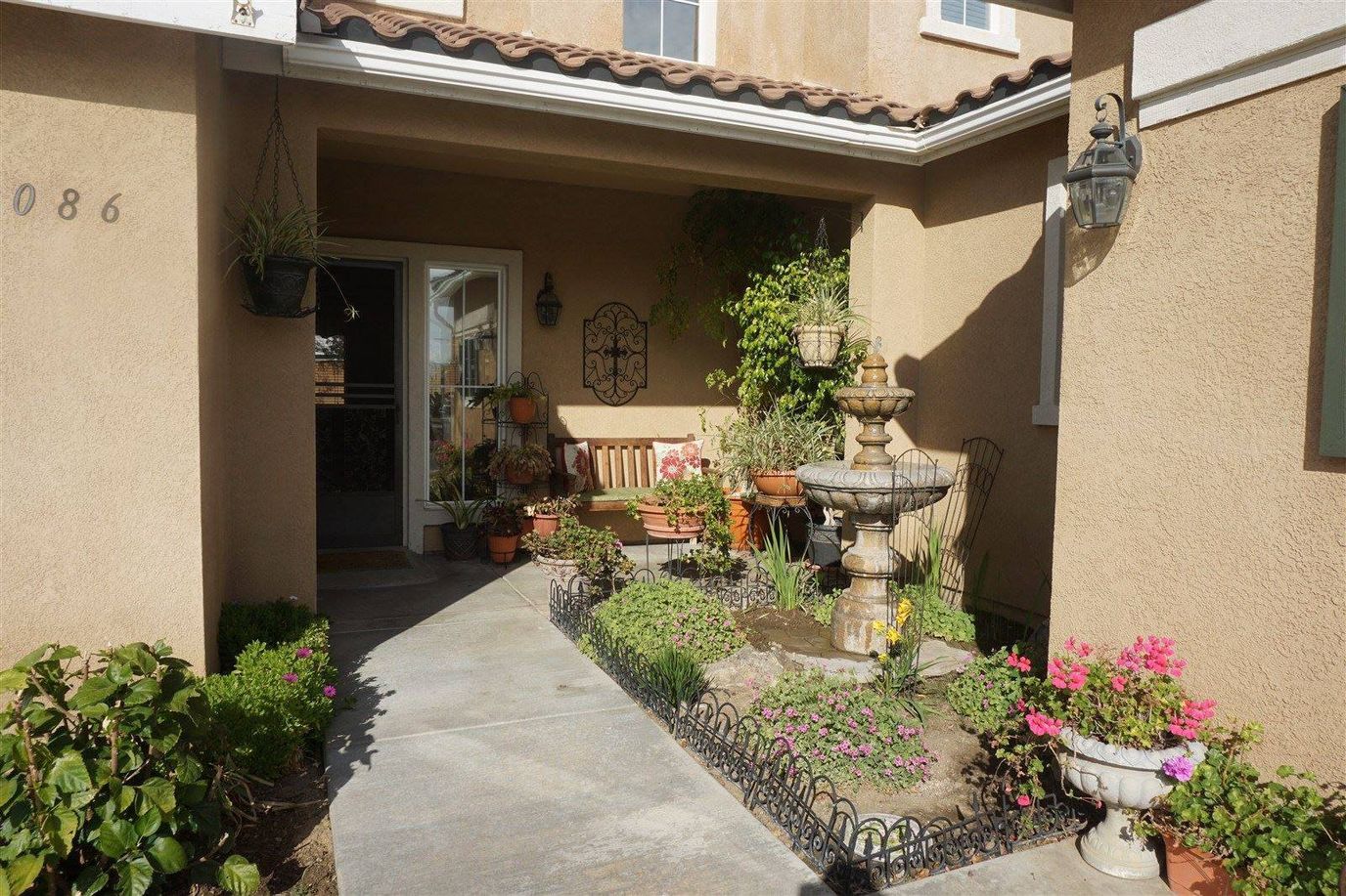Charming outdoor entrance with flowers and fountain