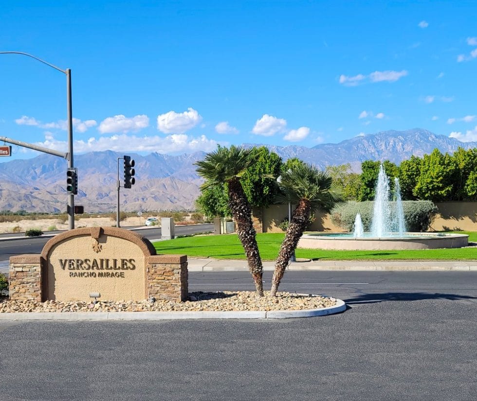 Entrance sign of Versailles facility with mountains in the background