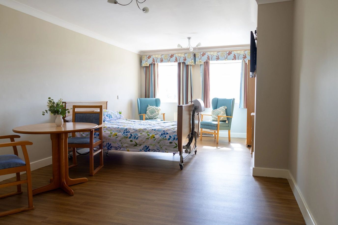 Bright interior of a resident room with a bed and seating area