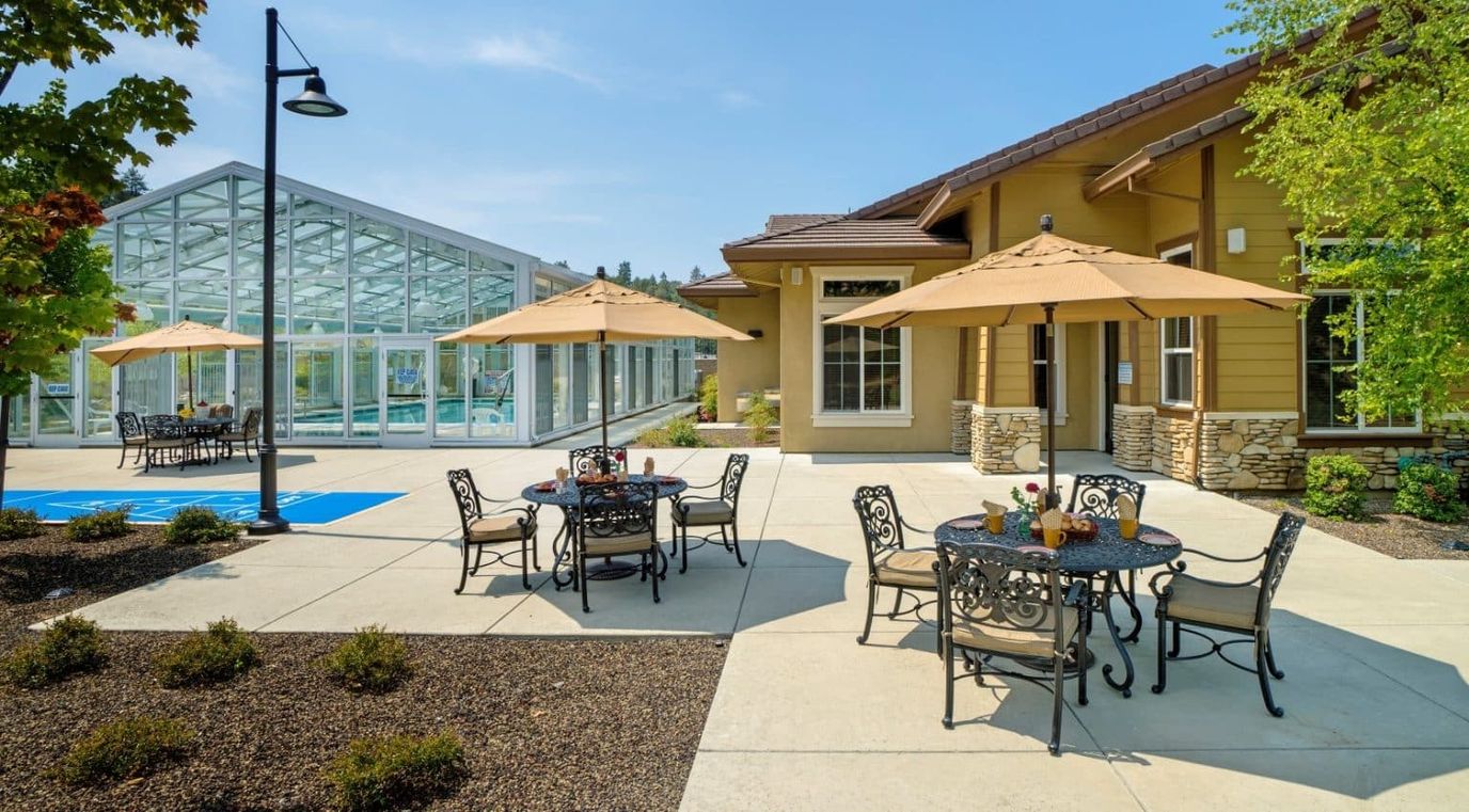 Outdoor seating area with umbrellas and glass structure