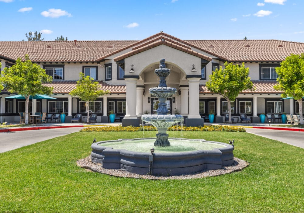 Exterior view of a senior living facility with a fountain