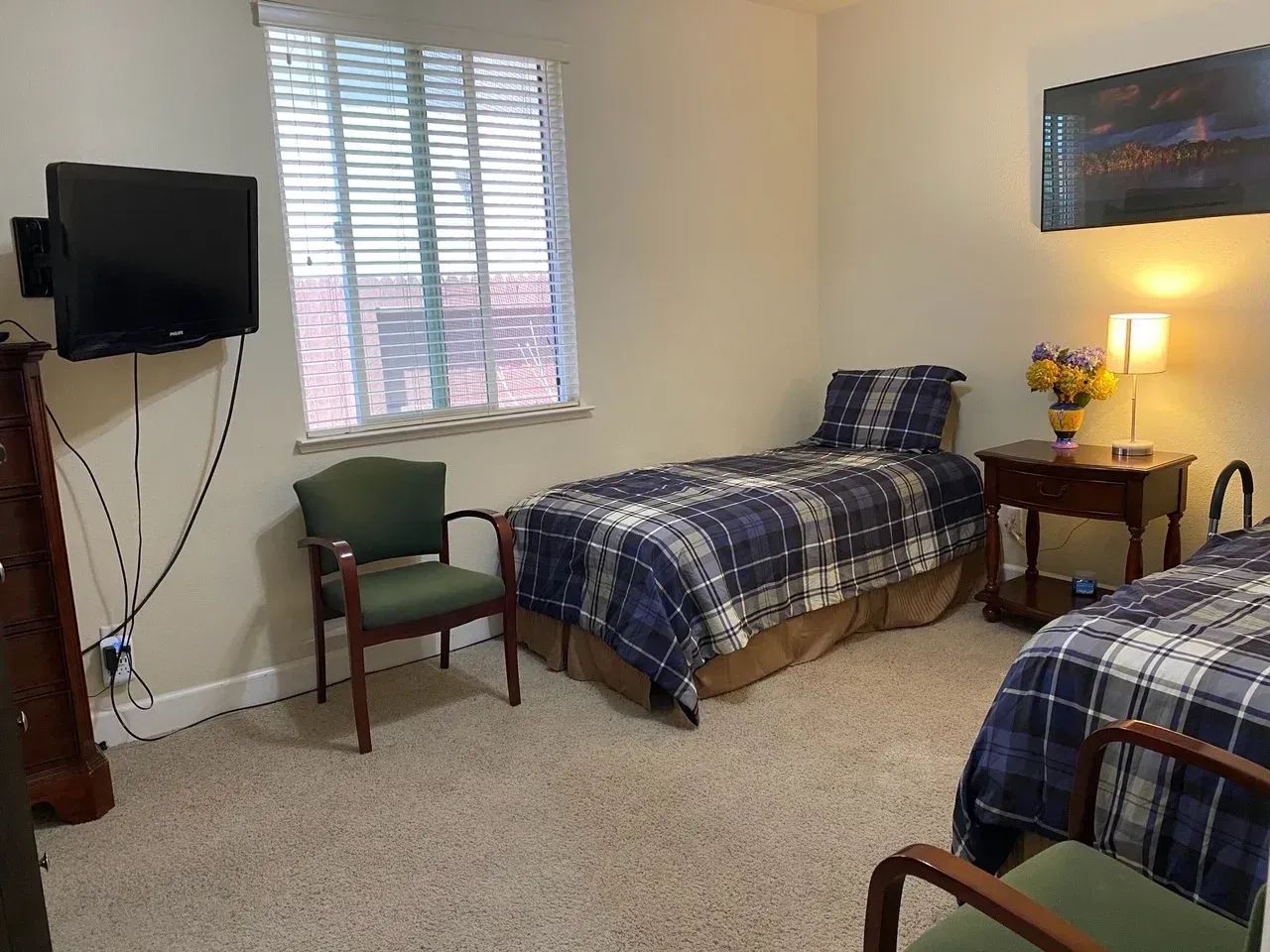 Private resident room with two beds and a TV