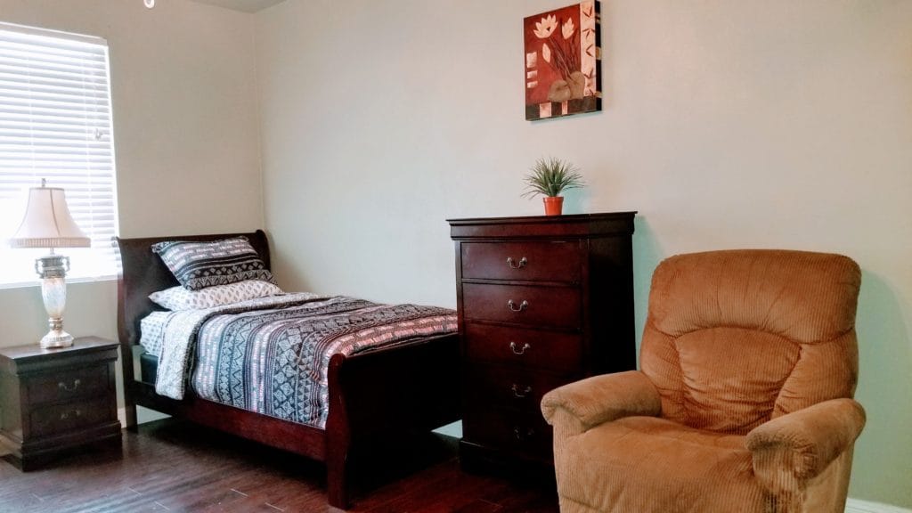 Cozy private resident room with a bed and chair
