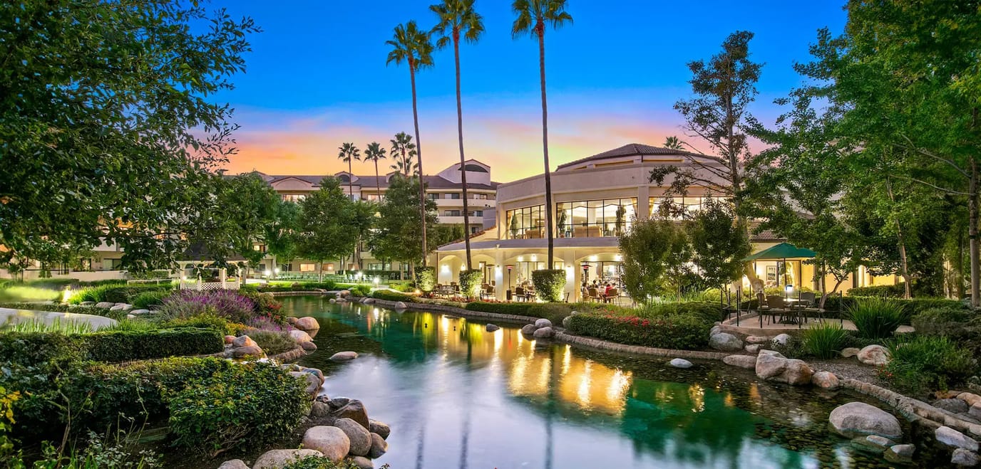 Exterior view of a senior living facility at sunset