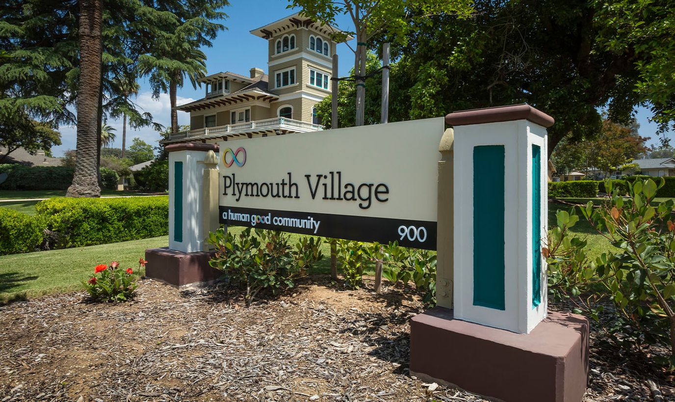 Signage for Plymouth Village surrounded by landscaping