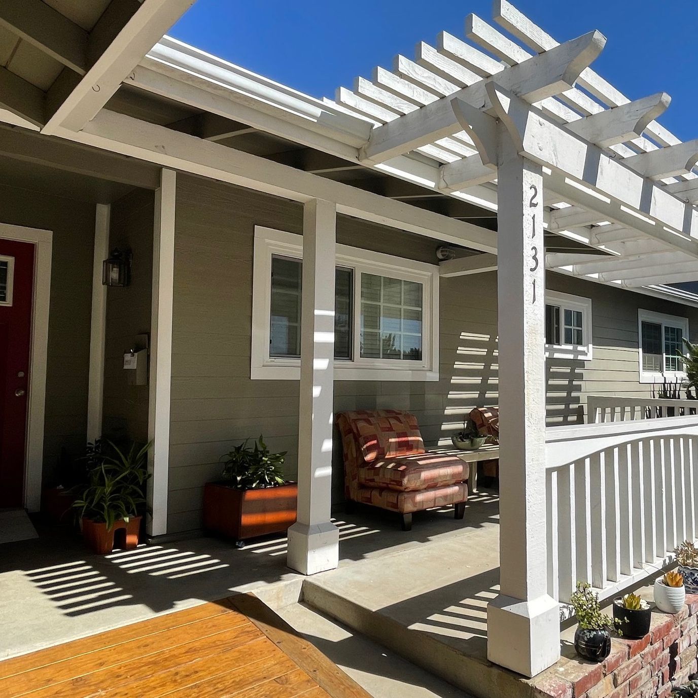 Covered patio area with chairs and plants