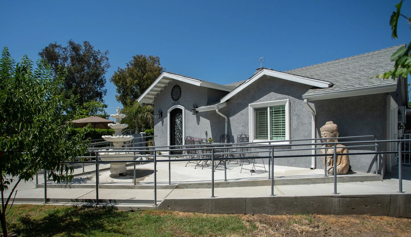 Exterior view of a senior care facility with a patio and fountain