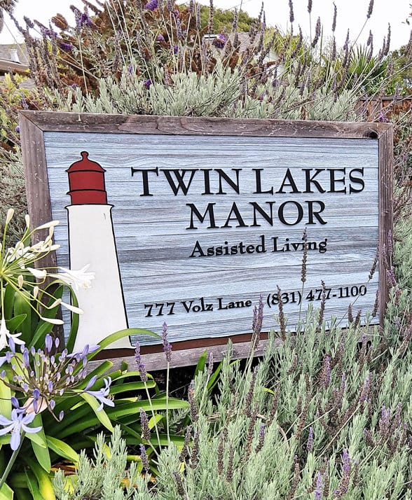 Signage for Twin Lakes Manor with flowers