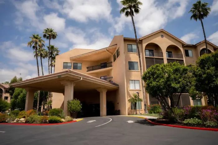 Front entrance of assisted living facility with palm trees