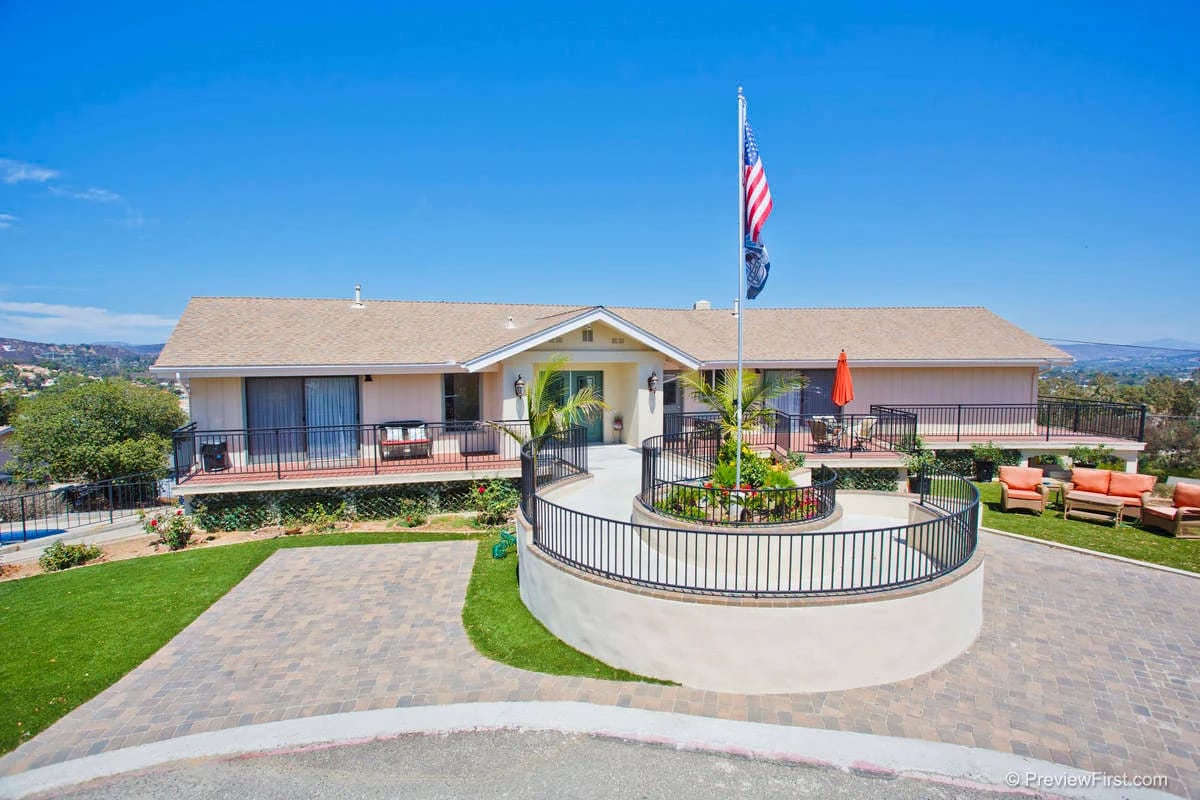 Exterior view of Champine Manor with gardens and seating area