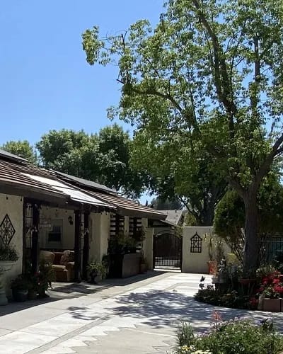 Outdoor view of a residence with trees and flowers