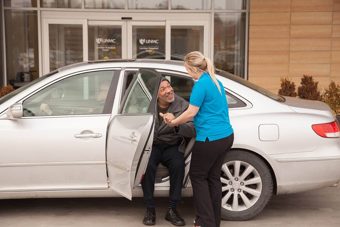 Staff assisting a resident from a vehicle