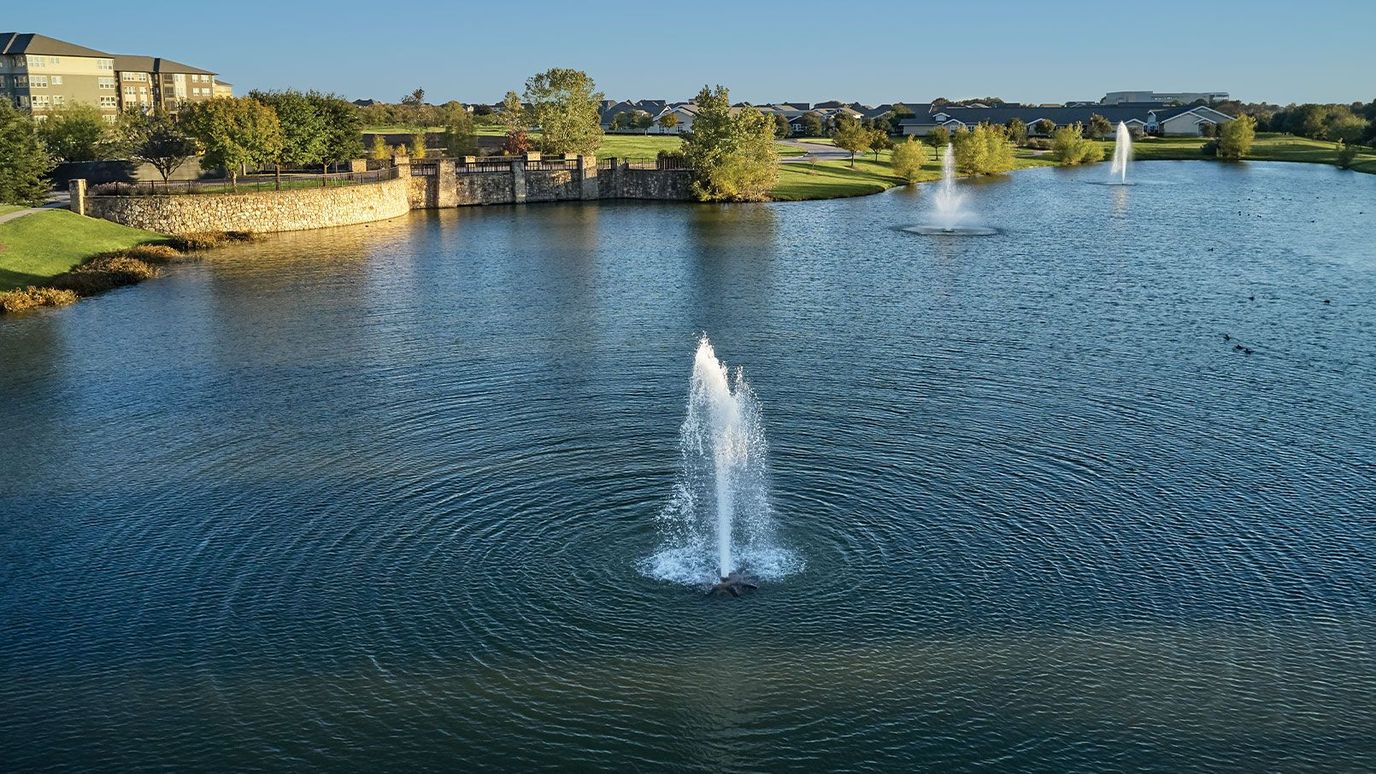 A serene view of a fountain in a large pond