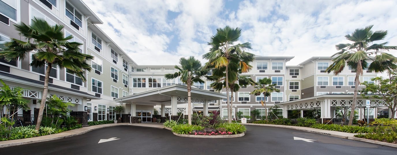 Front entrance of The Plaza Moanalualani with palm trees