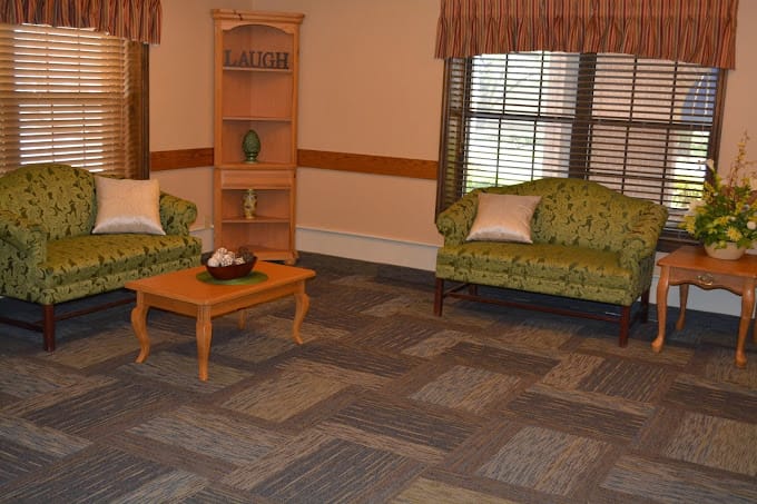 Cozy common area with green sofas and natural light