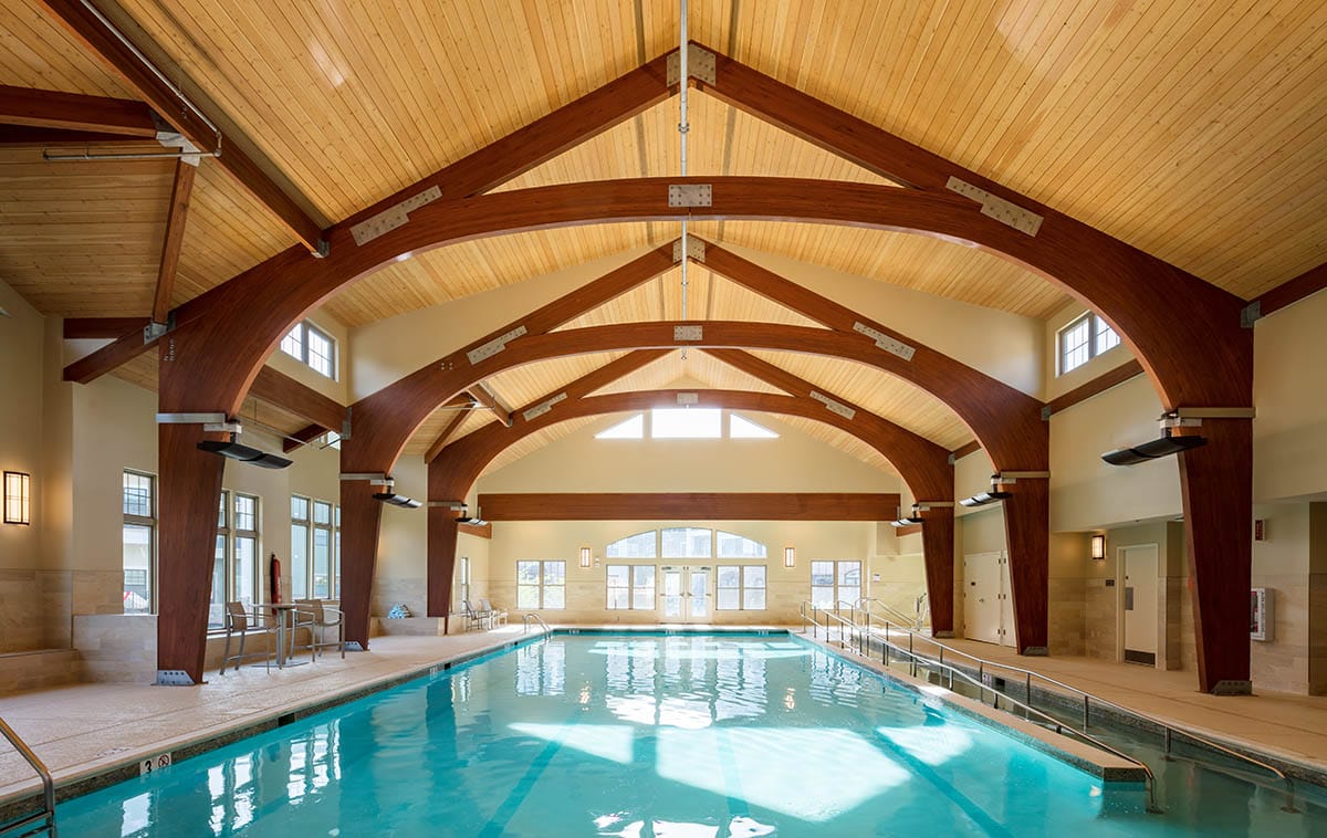 Interior view of a swimming pool area with wood beams