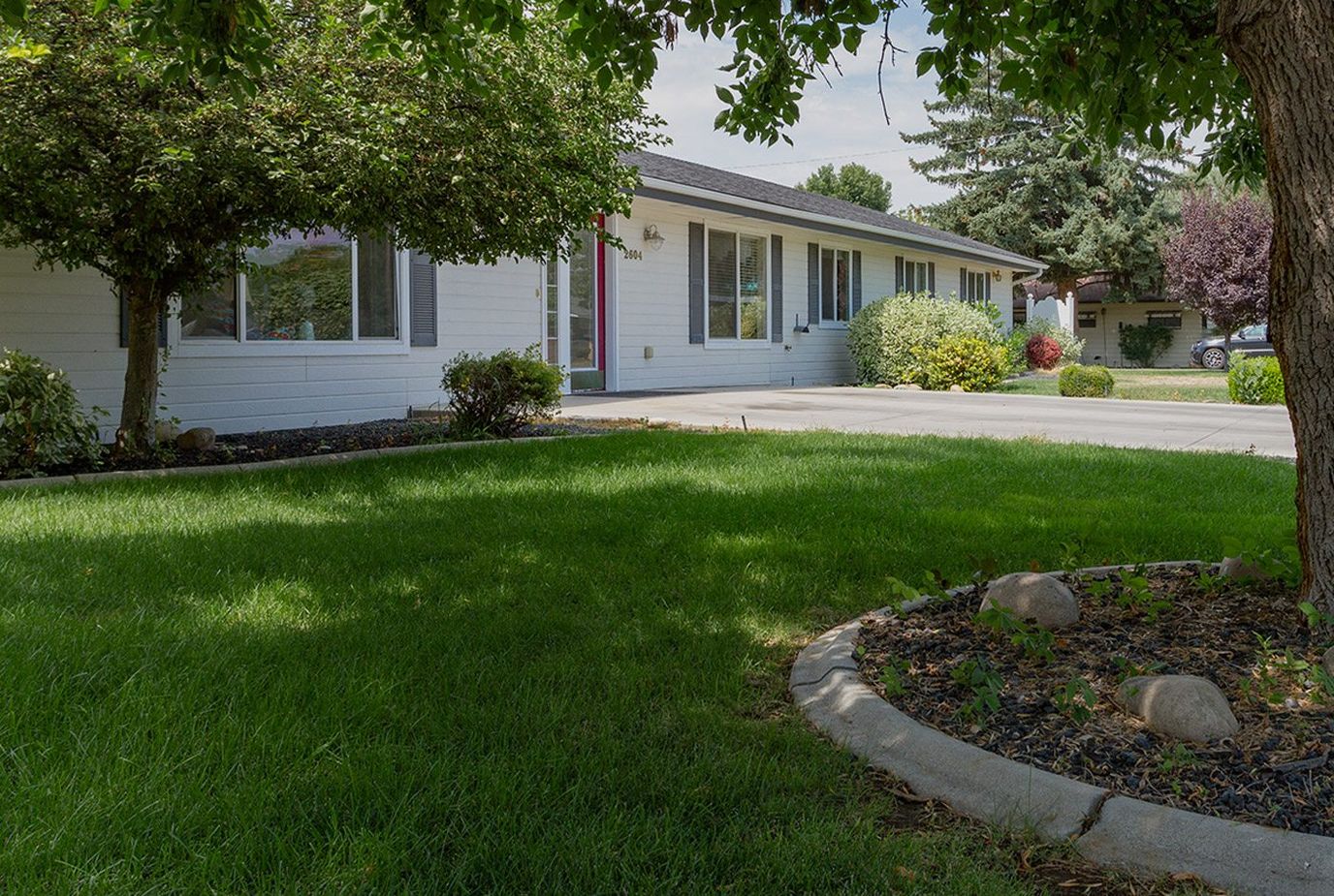 Exterior view of a senior living facility with green lawn