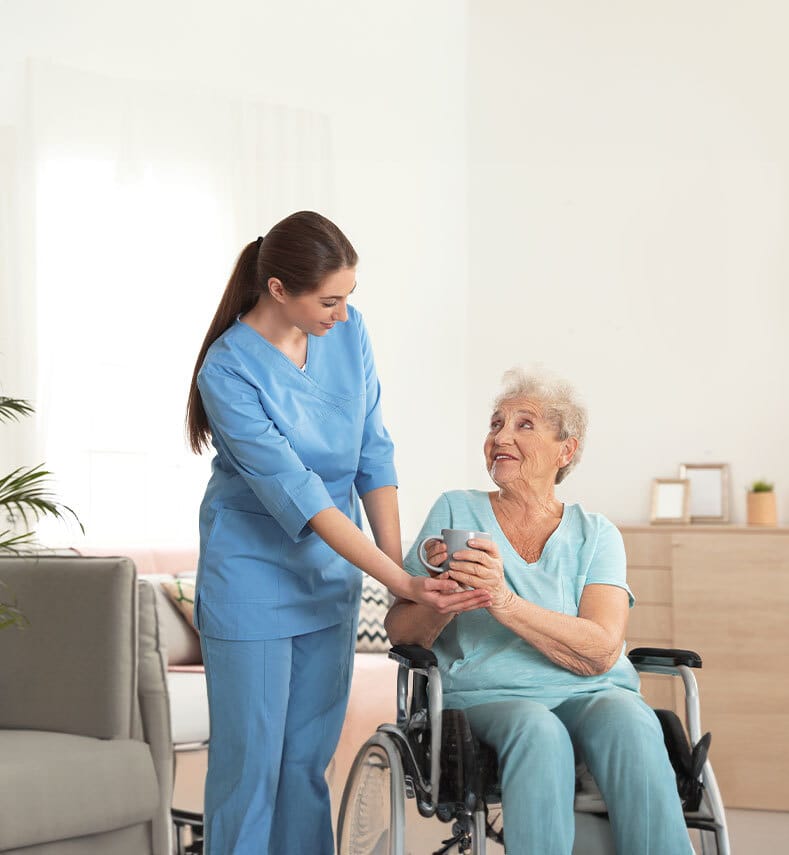 Caregiver assisting an elderly woman in a living space.