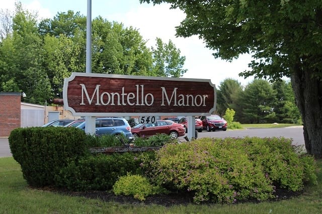 Signage for Montello Manor with surrounding greenery