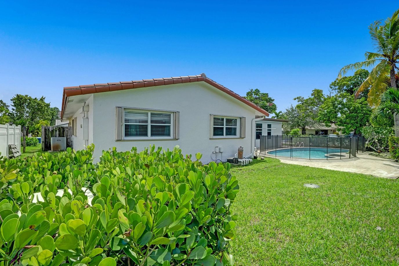 Exterior view of a building with pool and landscaping.