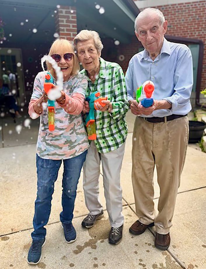Residents enjoying a water gun activity outdoors