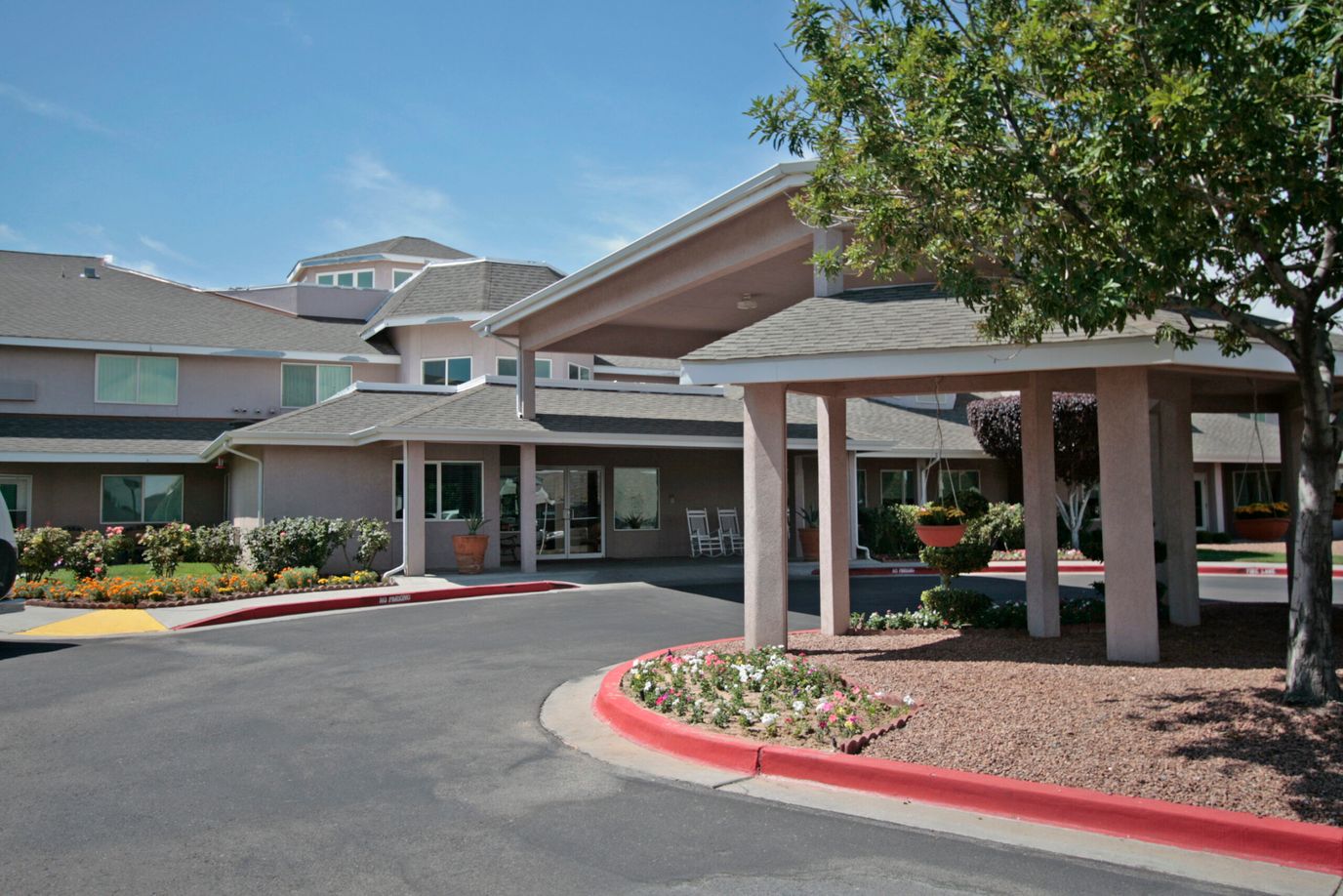 Entrance of a senior living facility with gardens and walkways