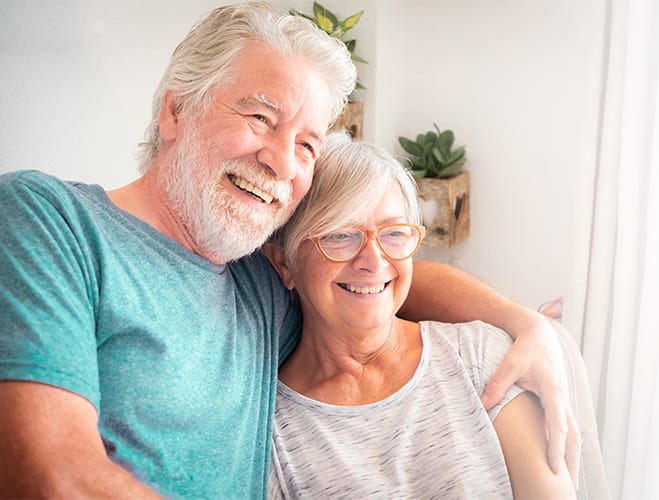 Two smiling seniors sitting together.