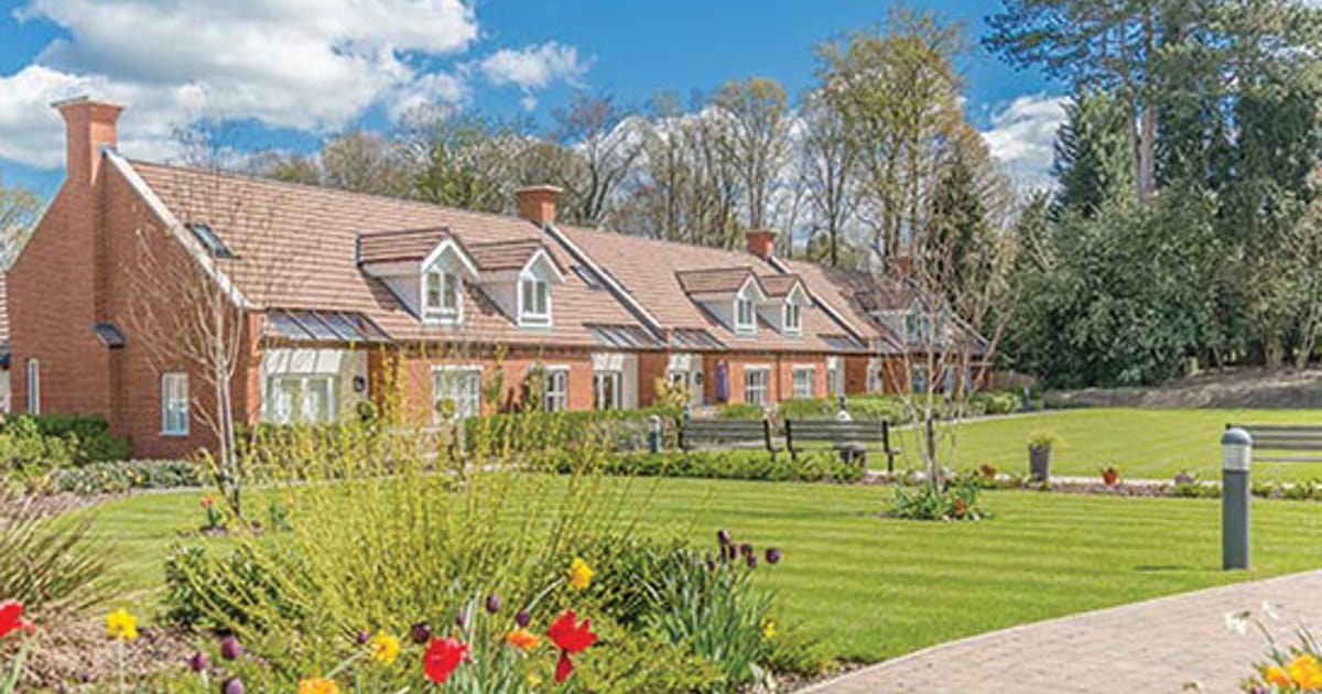 Exterior view of the assisted living facility with gardens