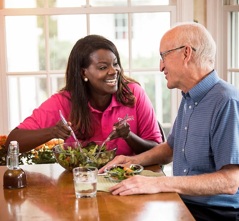 Caregiver and senior enjoying a meal together