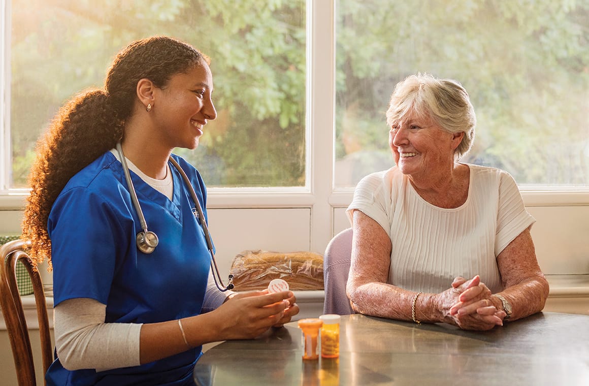 A caregiver talking with a senior resident indoors