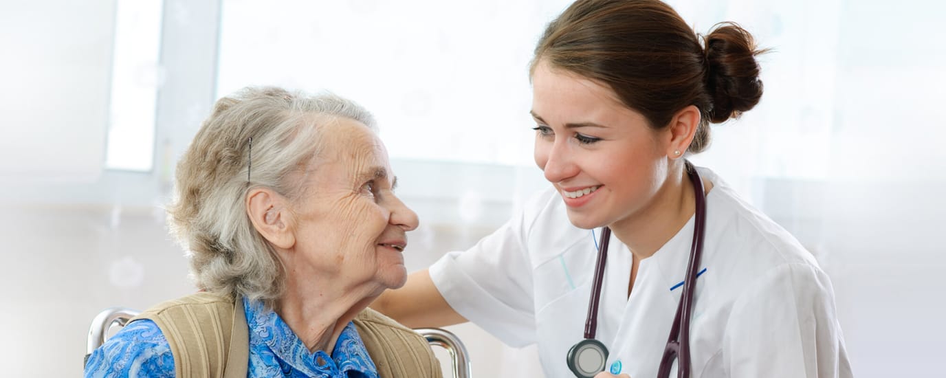 A caregiver smiling and interacting with a resident