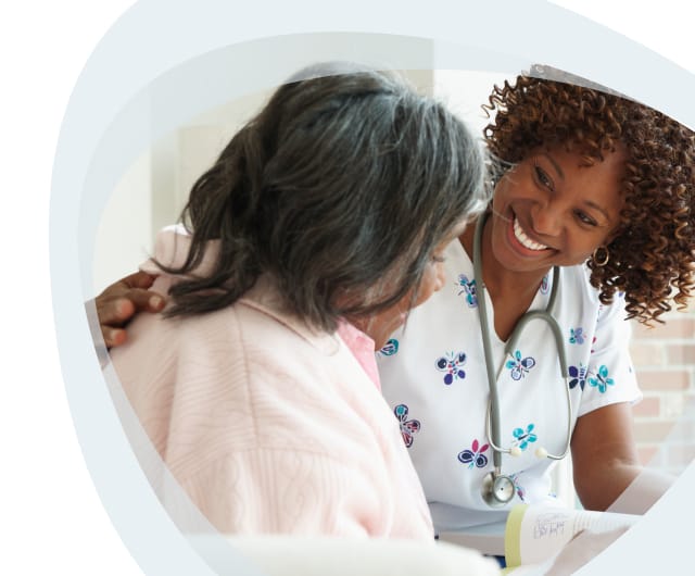 Nurse smiling with a resident in a comfortable setting.