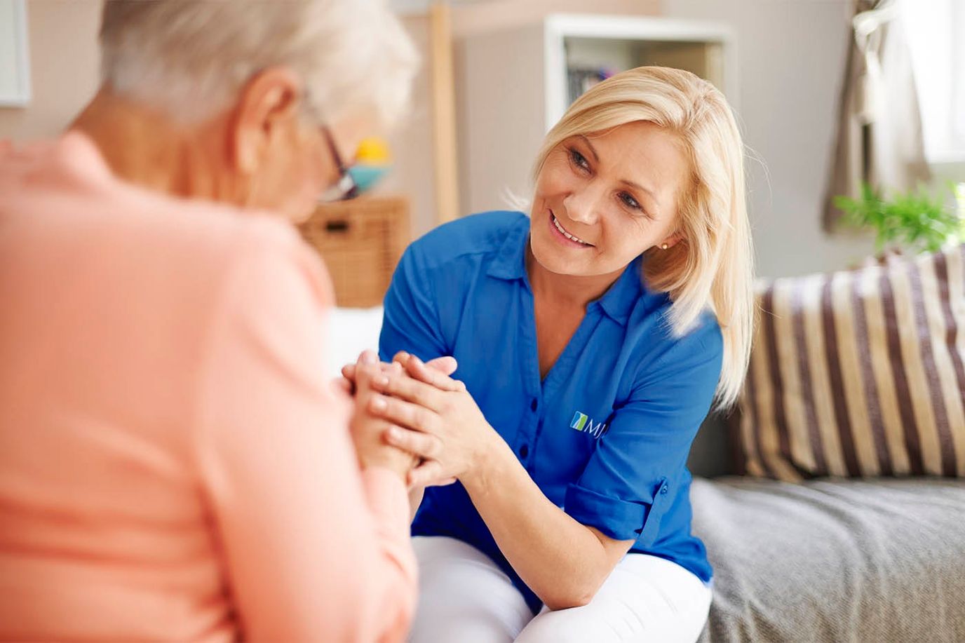 Caregiver interacting with a senior resident in a cozy interior