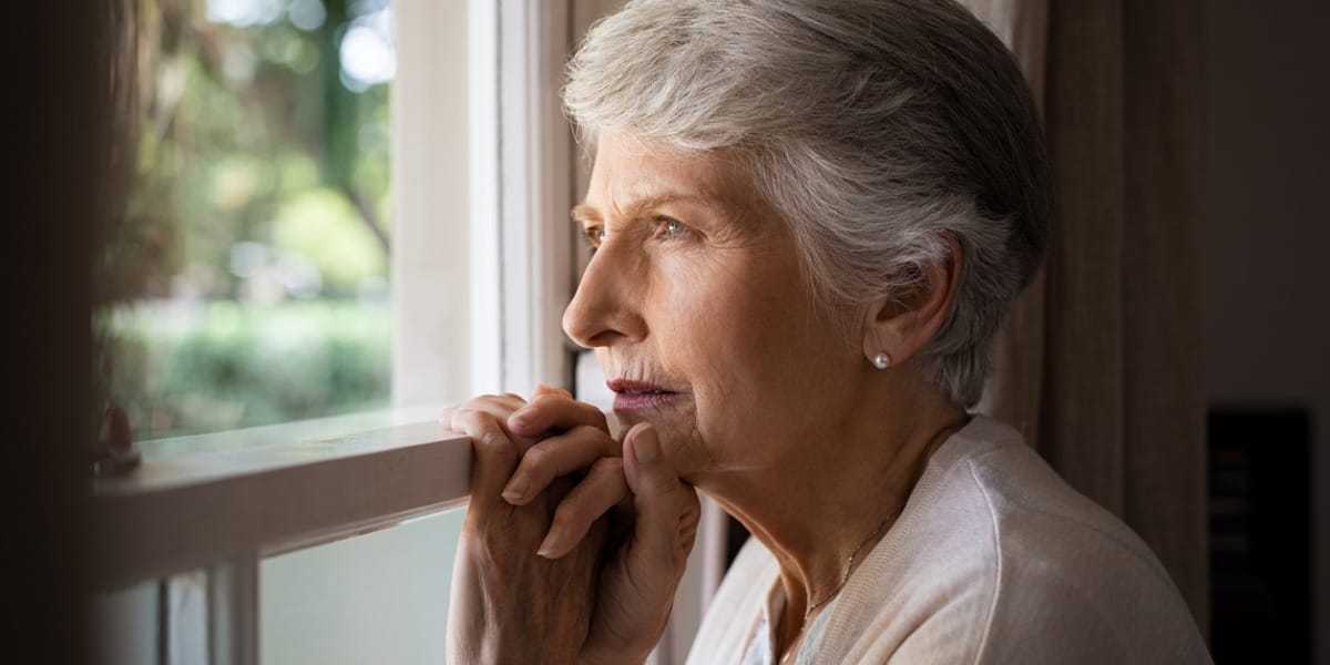 Senior woman looking thoughtfully out the window