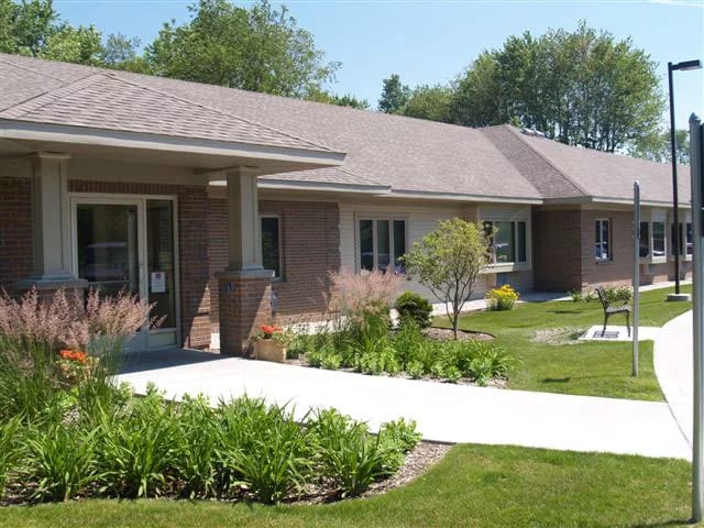 Exterior view of Grand Pines Assisted Living Center with landscaping