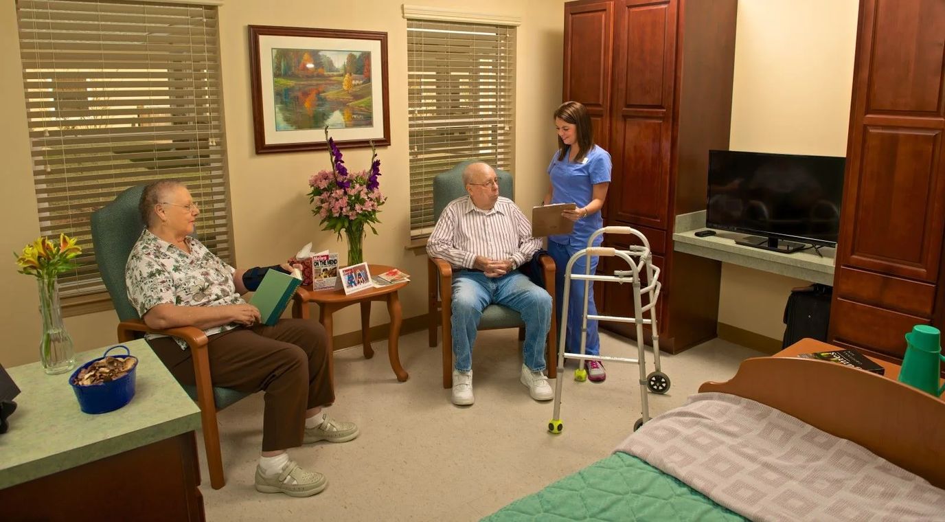 Residents in a cozy room with staff assistance