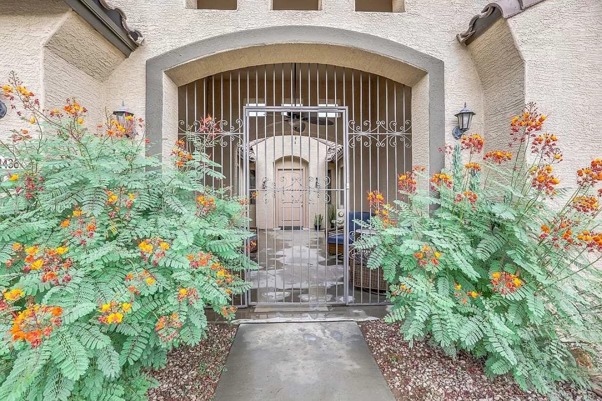 Entrance gate with flowers and buildings