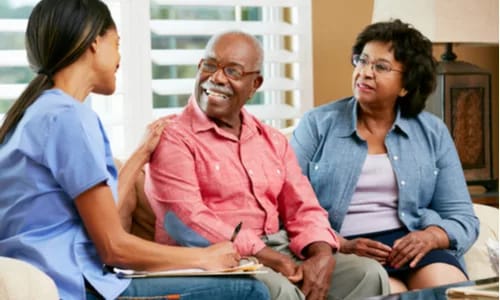 Residents interacting with staff in a cozy interior setting