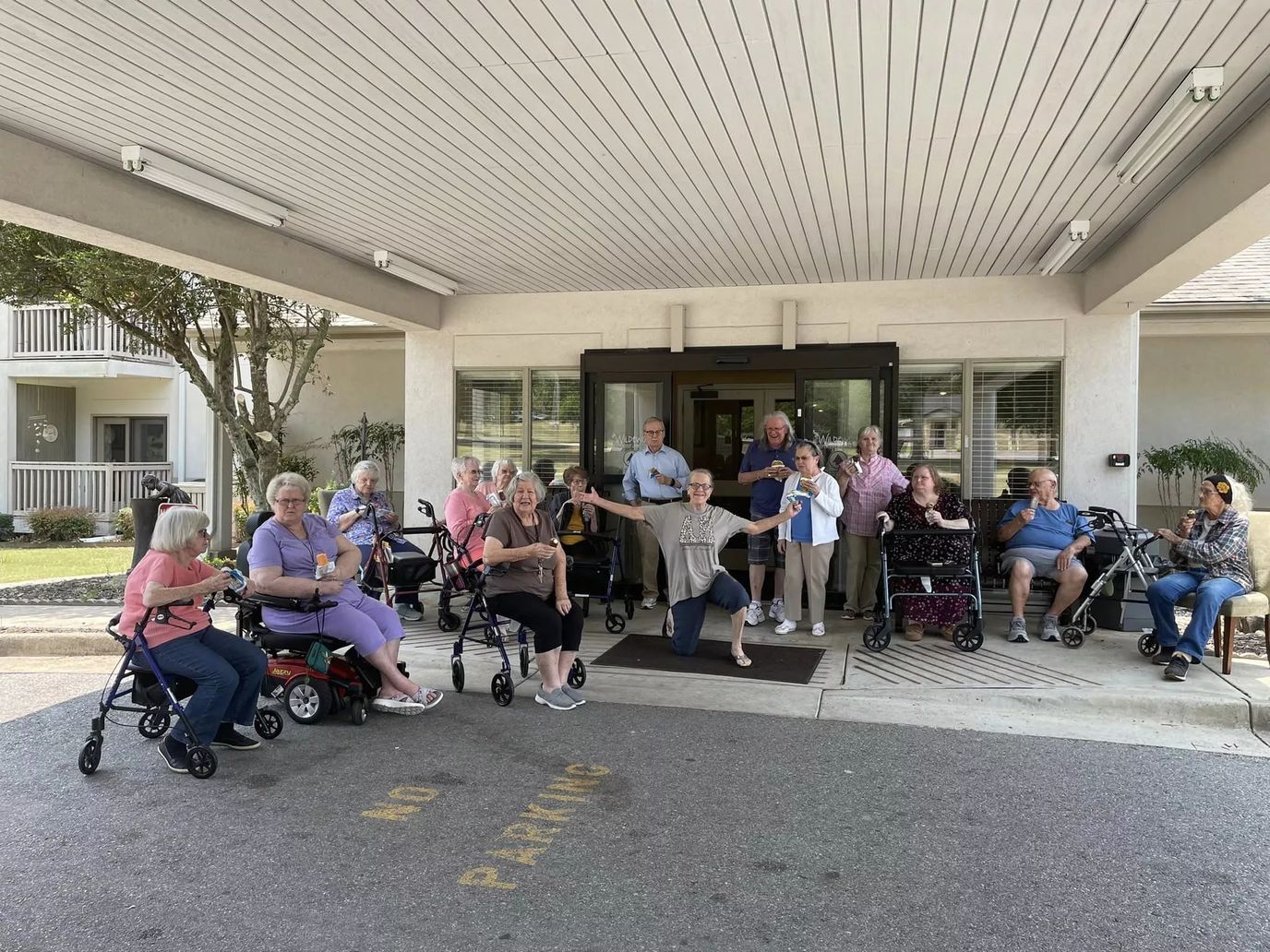 Residents gathered outside the facility entrance, smiling and enjoying time together