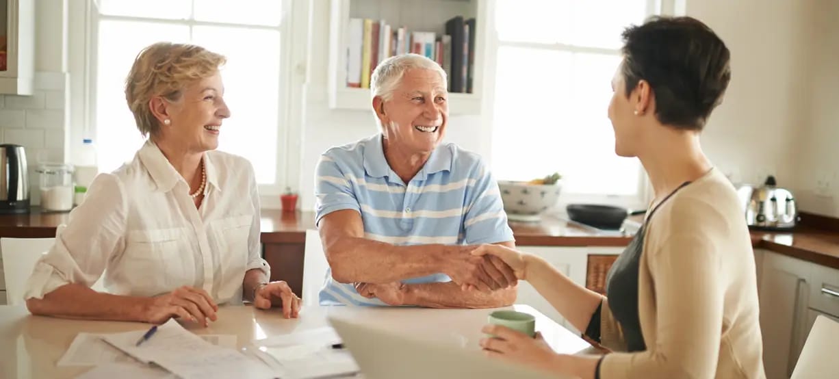 Two seniors and a caregiver at a table